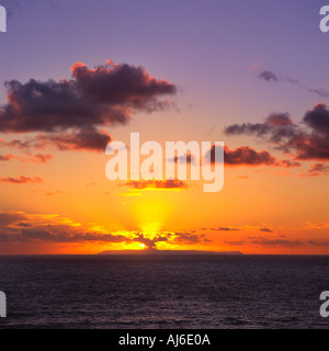Blick auf Lundy Island von Putsborough in der Nähe von Woolacombe mit grauen Wolken bei Sonnenuntergang über Lundy ist North Devon England beleuchtet Stockfoto