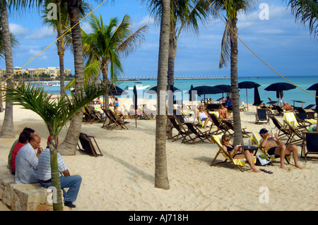 Urlauber und einheimische Männer entspannen Sie am Strand von Playa del Carmen Stockfoto