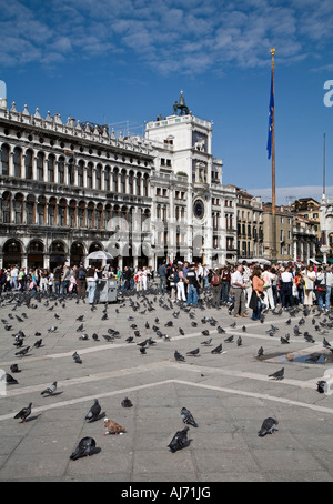Touristen und Tauben vor der Procuratie Vecchie Bögen, Piazza San Marco, Venedig, Italien. Stockfoto