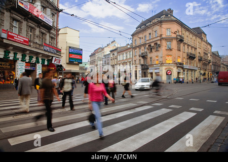 Fußgänger überqueren eine viel befahrenen Straße in Krakau. Krakau war auf der ersten UNESCO-Weltkulturerbe. Stockfoto
