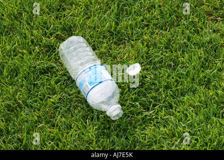 Weggeworfene leere Wasserflasche auf dem Rasen Stockfoto