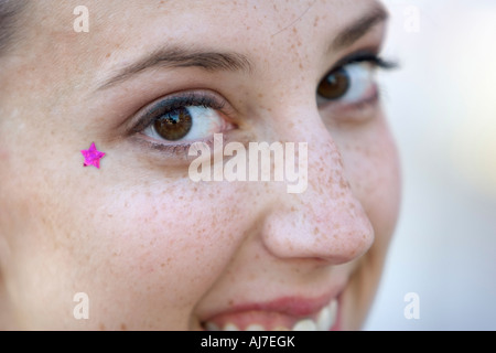 Ein Closeup Portrait einer kaukasischen Frau lächelnd.  Sterne Aufkleber von ihrem rechten Auge. Stockfoto