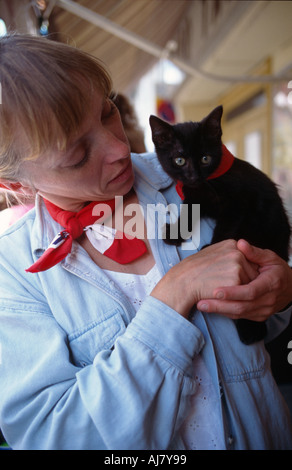 Frau und junge schwarzes Kätzchen, Feria de Pentecôte, Nîmes, Languedoc-Roussillon, Frankreich Stockfoto