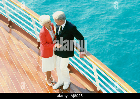 Reife Tourist paar auf Kreuzfahrt Schiffsdeck in der Nähe von Geländer mit Blick auf türkisfarbenes Wasser Stockfoto