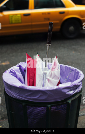 Wind beschädigt gebrochen Regenschirm im Abfallbehälter auf 49th Street Manhattan New York NY Stockfoto