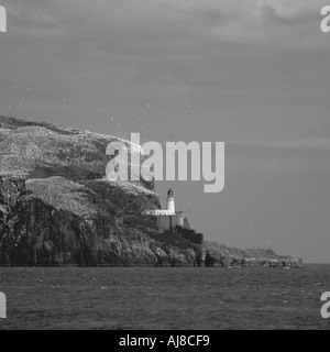 Leuchtturm in der Ferne auf einer Klippe Stockfoto