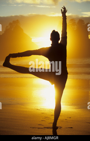 Yoga-Pose am Strand bei Sonnenuntergang. Stockfoto