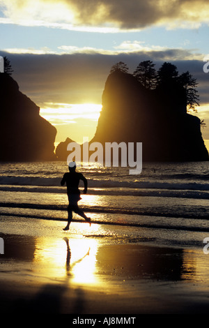 Läufer bei Sonnenuntergang am Strand. Stockfoto