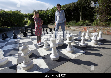 Mädchen im Alter von 9 und jungen im Alter von 15 spielen Schach auf ein Riese auf einem Grundstück von Burton Agnes Hall East Yorkshire UK Stockfoto