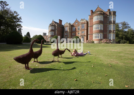 Mädchen im Alter von 9 spielen mit einer Statue von einer Ente auf dem Gelände des Burton Agnes Hall Bridlington East Yorkshire UK Stockfoto