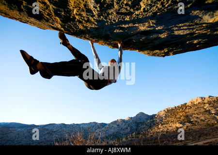 Frau Bouldern auf einem Überhang Stockfoto