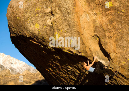 Frau Bouldern auf einem Überhang Stockfoto