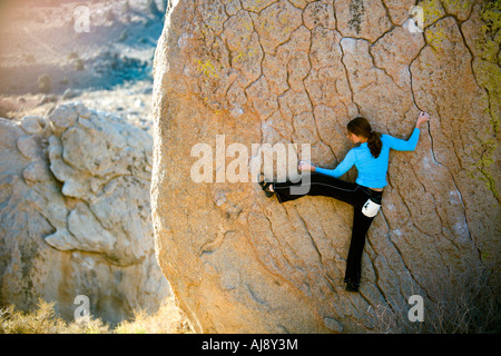 Frau Bouldern auf einem Überhang Stockfoto