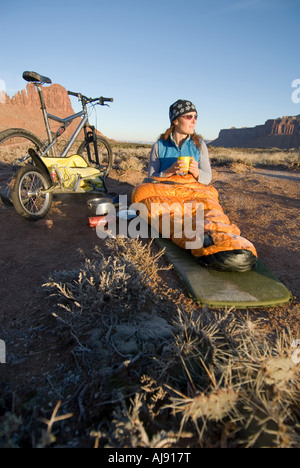 Frau im Schlafsack mit Heißgetränk. Stockfoto