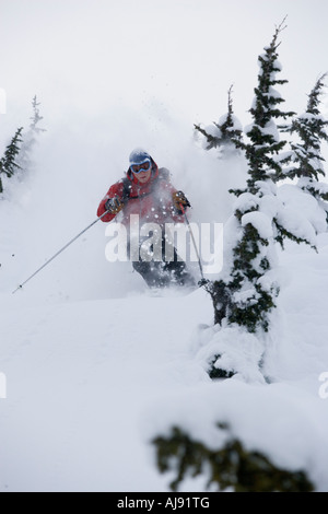 Junger Mann Ski im Tiefschnee Stockfoto