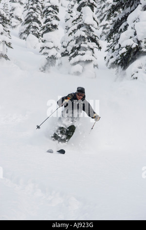 Junger Mann Ski im Tiefschnee Stockfoto