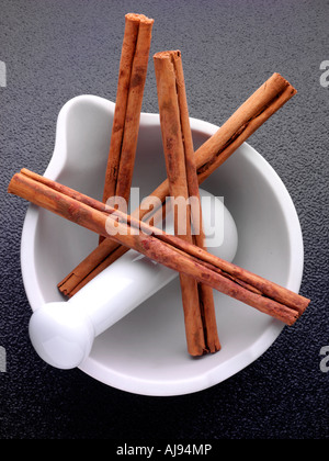 ZIMTSTANGEN IN MÖRSER Stockfoto