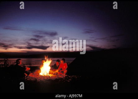 Freunde um Lagerfeuer sitzen. Stockfoto