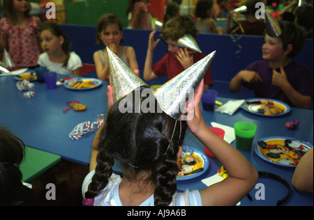 Eine Mädchen passt ihren Hut war eine Geburtstagsfeier in einem Childrens Tätigkeit Zentrum, Stoke Newington, London, UK. Stockfoto