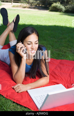 Frau mit Handy und Laptop Stockfoto