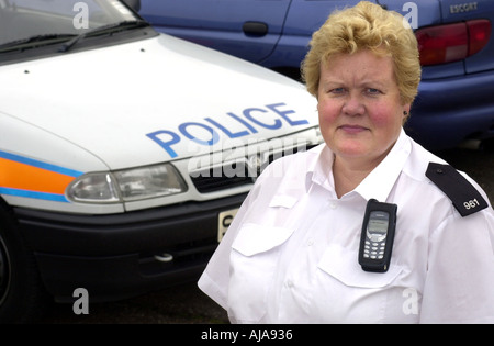 Polizist steht neben einem Streifenwagen Stockfoto