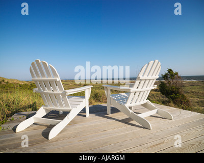 Zwei Adirondack Stühle auf hölzernen deck mit Blick auf Strand an Bald Head Island North Carolina Stockfoto