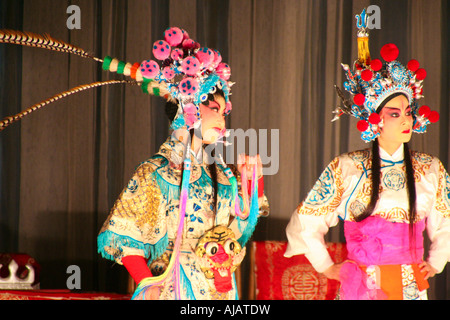 Zwei junge und talentierte Schauspielerinnen der Chengdu Oper gekleidet in traditioneller Kleidung durchführen auf der Bühne. Stockfoto