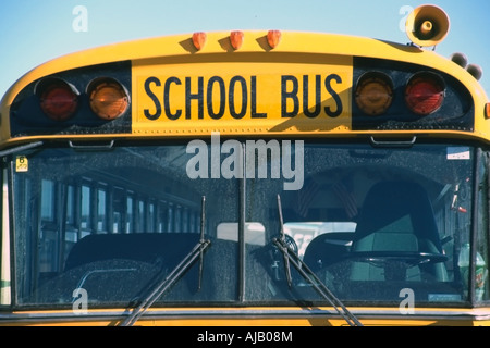 Ein Kopf auf, ganz nah Blick auf einen hellen gelben Schulbus. Seine "Windschutzscheibe dominiert den Rahmen, mit den Worten"Schulbus"Fett. Stockfoto