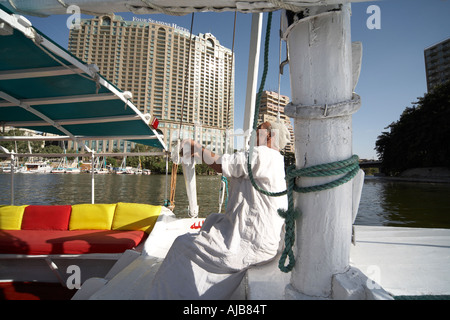 Ägyptische Boot Mann in traditioneller Galibeya Robe Feluke Segeln Ruderboot Kairo Ägypten Afrika Stockfoto