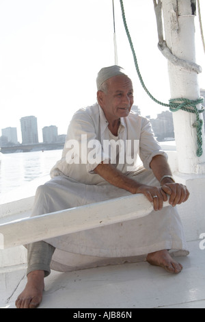 Ägyptische Boot Mann in traditioneller Galibeya Robe Feluke Segeln Ruderboot am Fluss Nil Kairo Ägypten Afrika Stockfoto