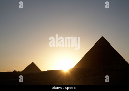 Pyramiden von Khafre Chefren und Menkaure Mycerinus bei der Festlegung der Sonne Sihouette Abend bei Sonnenuntergang Gizeh Kairo Ägypten Afrika Stockfoto