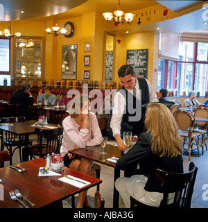 Kellner servieren zwei junge Frauen American Diner Essen in einem Restaurant Cafe Rouge in London England HXXZsmng Stockfoto
