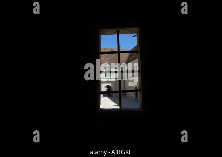 Blick durch eine mittelalterliche Fenster aus ein schwarzes Interieur Stockfoto