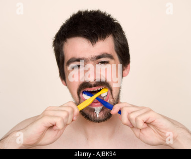 Mann mit zwei Zahnbürsten Zähneputzen, Nahaufnahme Stockfoto