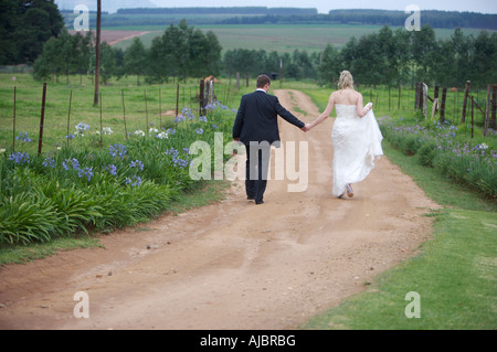 Braut und Bräutigam zu Fuß auf Feldweg Stockfoto