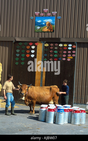 zwei Bauern mit Cowand Milchkannen stand vor einem Stall Stockfoto