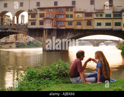 Paar beim Sonnenuntergang Toast am Fluss Arno in der Nähe von Ponte Vecchio in Florenz Stockfoto