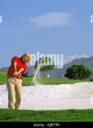 Frau Golfer Strahlen schoss aus Sandfang oder bunker Stockfoto