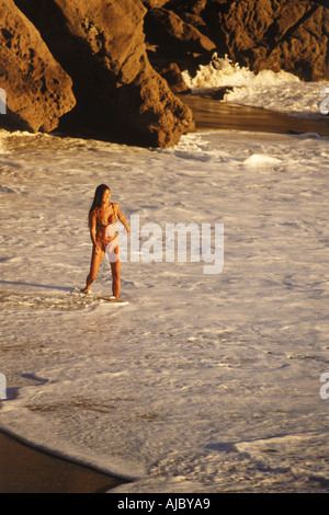 Frau spielt in Wellen am Ufer der Laguna Beach bei Sonnenuntergang in Kalifornien Stockfoto