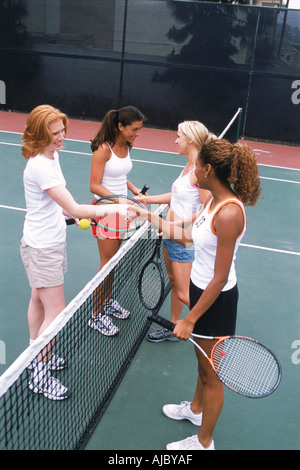 Vier Frauen aus ethnischen Mischung Händeschütteln nach Tennis spielen Stockfoto