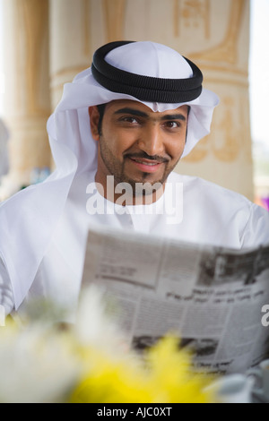 Arab Business Mann lesen Zeitung auf Terrasse Stockfoto