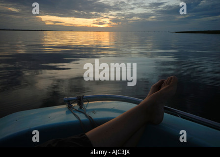 Ruhige Szene ein Womans Beine ruhen auf der Seite eines Bootes auf dem Wasser Stockfoto