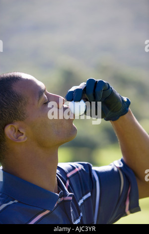 Nahaufnahme von Mann küssen Golfball Stockfoto