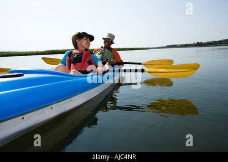 Afrikanischer Amerikaner mittleren gealterten paar sitzt im Kajak auf See Lächeln und lachen Stockfoto