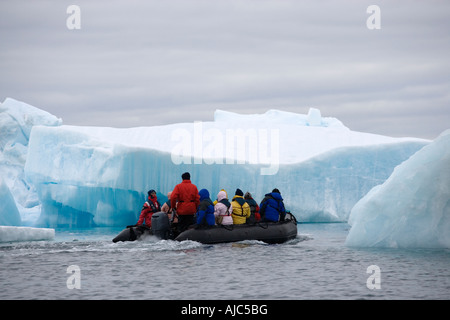 Touristen in einem Zodiac anzeigen und Eisberg Stockfoto