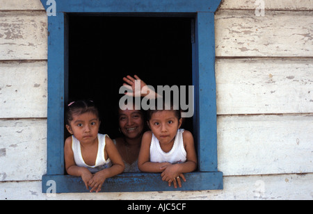 Mutter und Töchter Blick aus dem Fenster ihrer hölzernen Haus San Sebastian Retalhuleu Guatemala Stockfoto