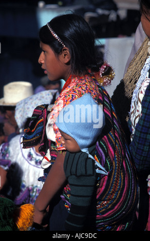 Mädchen aus Nahuala mit kleinen Bruder von ihrer Hüfte San Francisco el Alto Markt der größte Freiluftmarkt in Guatemala Stockfoto