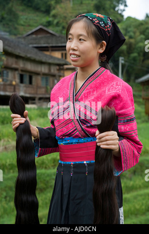 Eine Red Yao Mädchen hält zwei neue Zöpfe der Haare einer Frau s Mähne schon lange Haare Guilin China hinzugefügt werden Stockfoto