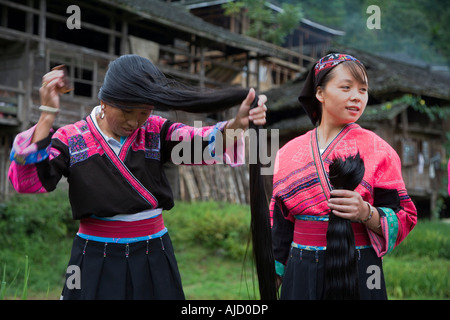 Langhaarige Yao Frau dabei ihr täglich Haare kämmen und Hinzufügen von Haarflechten, aufwendige Mähnen Guilin China schaffen Stockfoto