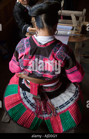 Eine rote Yao Frau sitzt an ihrem Webstuhl in traditioneller Tracht Guilin China Stockfoto